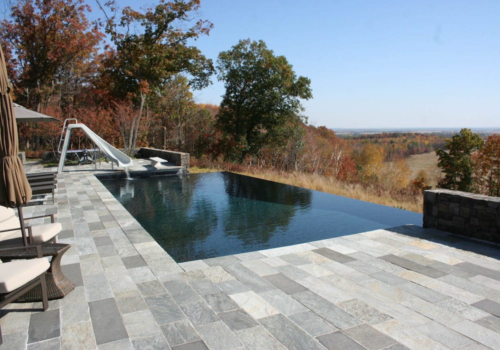 Swimming pool with slide in a residential backyard in autumn