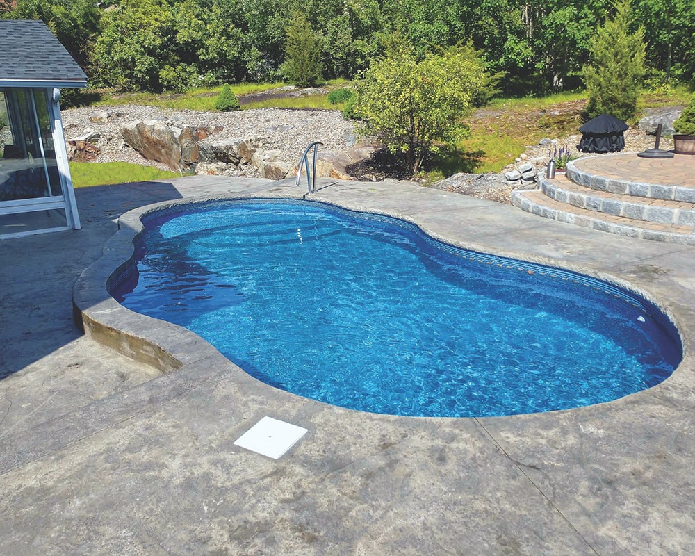 semi in-ground radiant pool surrounded by stone patio