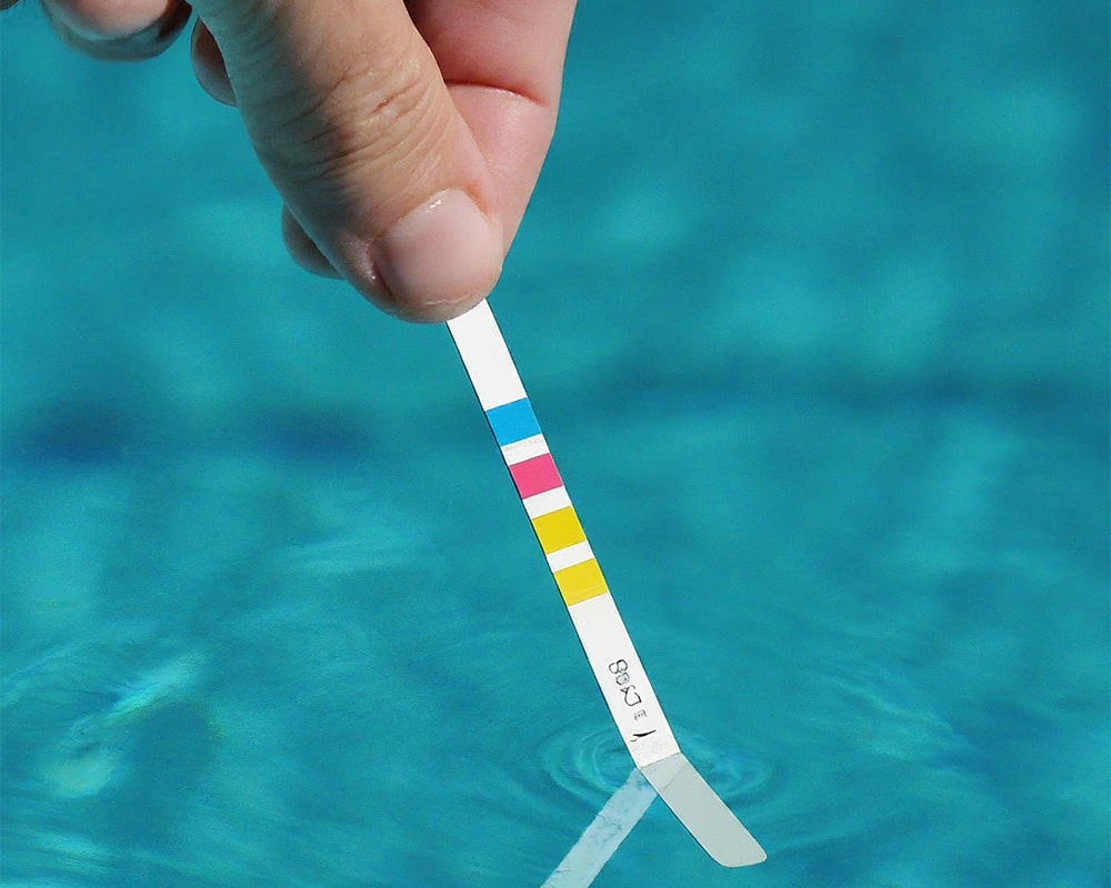 testing pool water with a test stripe